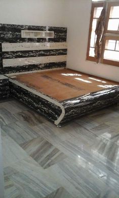 a bed that is made up with black and white wood grains on the headboard