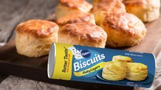 some biscuits are sitting on a wooden tray next to a can of biscuits