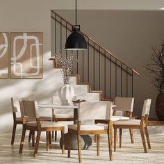 a dining room table with chairs and a vase on the table next to some stairs