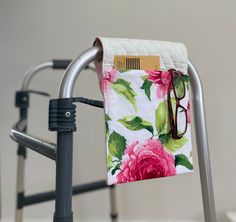 a pair of glasses sitting on top of a metal chair next to a flowered towel