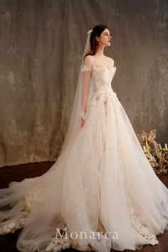 a woman in a wedding dress standing on a wooden floor with her veil pulled back