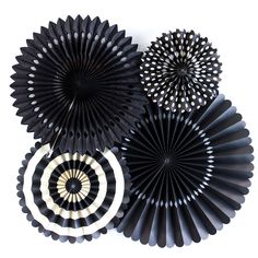 black paper fans with white circles on the top and bottom, hanging from a wall