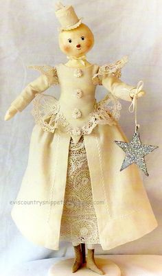 the doll is wearing a white dress and star ornament