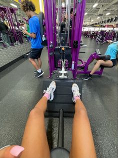 two people in a gym doing exercises on exercise machines with their feet resting on the machine