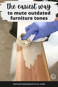 a person in blue gloves wiping paint off the top of a wooden table with text overlay that reads, the easier way to mitts are outdated furniture tones