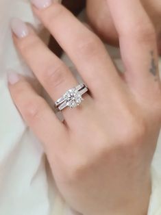 a woman's hand with a diamond ring on it