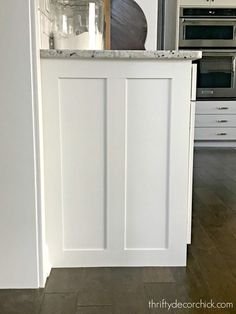 a kitchen with white cabinets and an island counter top in the middle of the room