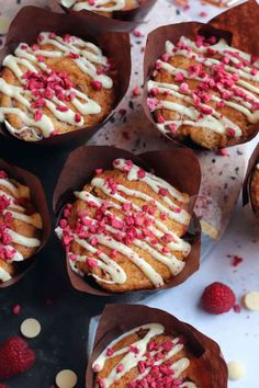 some cupcakes with white icing and pink sprinkles on them