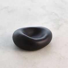 a black object sitting on top of a white floor next to a gray countertop