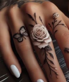 two fingers with tattoos and flowers on them