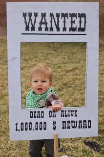 a baby standing in front of a wanted sign