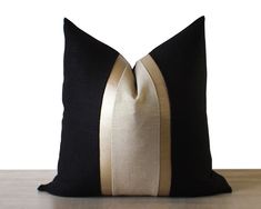 a black and gold pillow sitting on top of a wooden table