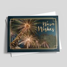 a card with the words warm wishes written on it and fireworks in the sky above