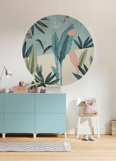 a living room with a blue cabinet and wall mural