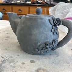 a ceramic tea pot with flowers on it