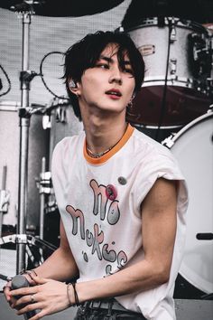 a young man sitting in front of a drum set