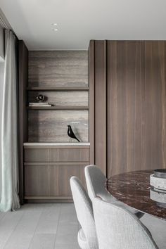 a dining room table with white chairs and wooden shelves