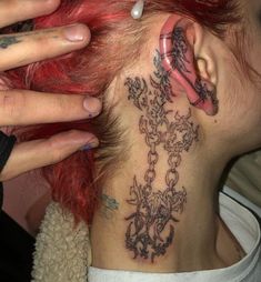 a woman with red hair has a tattoo on her neck and behind her ear,