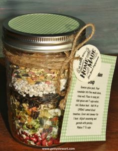 a jar filled with lots of different types of food next to a tag on a wooden table