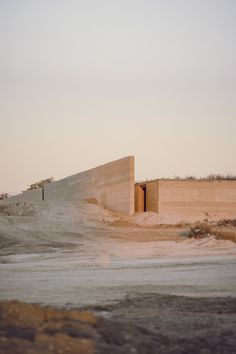 an empty parking lot next to a concrete wall