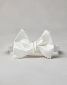 Cotton and silk satin bow tie An essential accessory for evening events, the cotton and silk satin bow tie completes tuxedos with classic flair. This accessory, which must be tied, is adjustable thanks to a convenient hook-and-loop closure behind the neck. Classic Pre-tied Satin Bow Tie, Classic Pre-tied Decorative Bow, Classic Adjustable Satin Bow Tie, Elegant White Bow Tie For Black-tie Events, Classic White Adjustable Bow Tie, Classic Pre-tied Satin Bow, Classic Pre-tied Tie With Decorative Bow, Classic Adjustable Bow With Detachable Feature, White Bow Tie For Formal Occasions