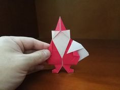 someone is holding an origami bird on a table