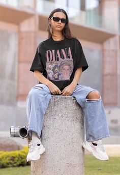 a woman sitting on top of a cement pillar