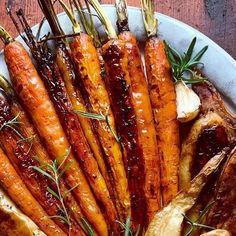 roasted carrots and onions on a plate with rosemary