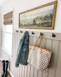 a coat rack with two purses hanging on it next to a pair of boots