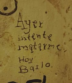 graffiti written on the side of a wall with writing in spanish and english, as well as an image of a man's face