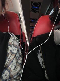 two people sitting in seats with headphones on