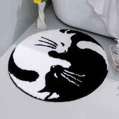 a black and white cat rug sitting on top of a bathroom counter