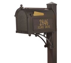 the mailbox is brown and has two letters on it, which are attached to a post