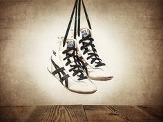 a pair of shoes hanging from a rope on top of a wooden floor in front of an instagram page