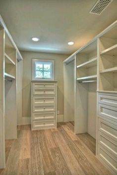 an empty walk in closet with lots of drawers