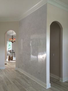 an empty room with hard wood floors and white walls in the middle of the room