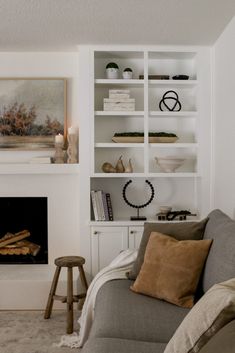 a living room filled with furniture and a fire place in front of a book shelf