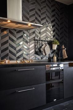 a kitchen with black cabinets and stainless steel stove top oven hoods on the wall