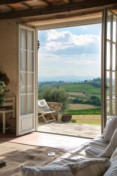 an open door leading to a patio with a view of the rolling hills and fields