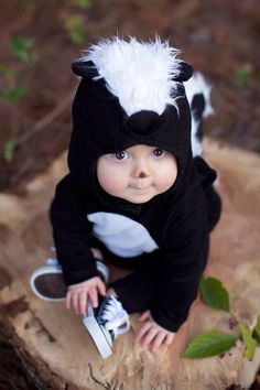 a baby dressed in a costume is sitting on the ground