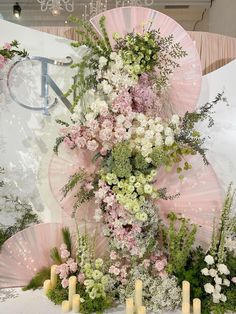 an arrangement of flowers and candles on display