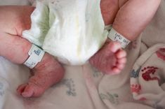 a close up of a baby laying on top of a bed wearing a diaper