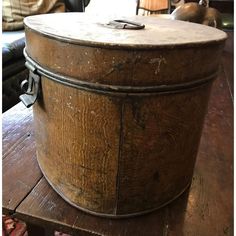 an old wooden box sitting on top of a table next to a leather chair and ottoman