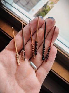 a hand holding four different colored tooth brushes