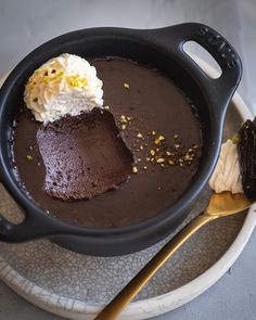 a chocolate dessert with ice cream and sprinkles in a black skillet