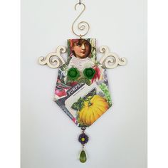 an ornament is hanging on the wall with pictures and charms attached to it