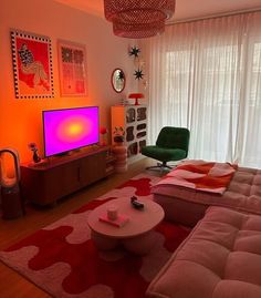 a living room filled with furniture and a flat screen tv on top of a stand