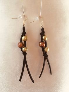 The Fringy Freak Earring ~ Super cool camo fringy earrings aet the trend in your deer blind or at the club. Black suede with brown and olive pearls. Perfect for any urban cowgirl! 4 inches long Hand made and hand knotted. Genuine Pearls. Leather or sueded cord. Sterling silver hooks on all earrings. Perfect Boho, beautiful, beachy, carefree look. Classic and stylish. Easy to dress up or down with jeans, wear daily - day or night, or for a night out. Perfect for layering. Because jewelry is made Leather Cord Earrings Diy, Leather And Pearl Earrings, Bead And Leather Earrings, Leather And Pearls, Earrings Made With Beads, Leather Cord Jewelry Diy, Leather Earrings Ideas, Leather Cord Earrings, Boho Earrings Diy