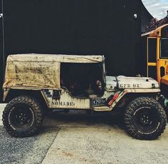 an old jeep is parked in front of a school bus