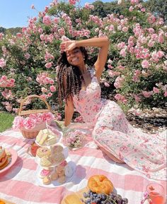 a woman sitting at a picnic table with food